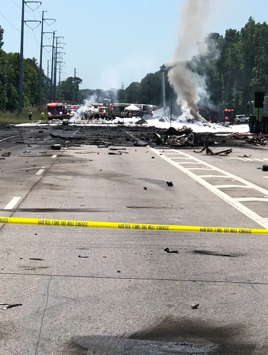 Personel darurat berada di lokasi jatuhnya pesawat kargo militer Amerika Serikat di jalan raya dekat bandara Savannah, Georgia, Rabu (2/5). Militer masih menyelidiki insiden jatuhnya pesawat berusia lebih dari 50 tahun tersebut. (James Lavine via AP)