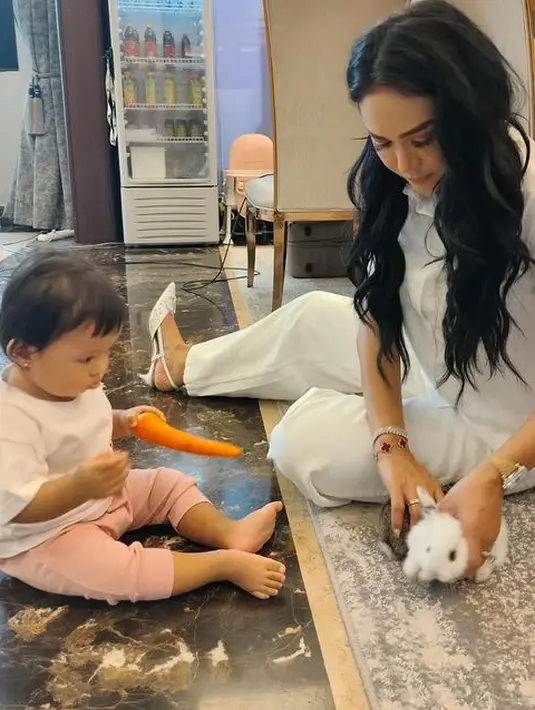 <p>Baby Ameena yang baru saja ulang tahun pertama itu tampak memegang wortel untuk makanan kelinci. Disela-sela kesibukannya, penyanyi berusia 47 tahun itu menyempatkan menengok cucu pertamanya. [Instagram/krisdayantilemos]</p>
