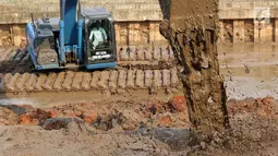 Alat berat mengeruk lumpur di kawasan Setu Babakan, Jakarta, Senin (7/5). Selain untuk menambah daya tampung air, pengerukan juga sebagai salah satu langkah pencegahan banjir di Ibu Kota. (Liputan6.com/Immanuel Antonius)