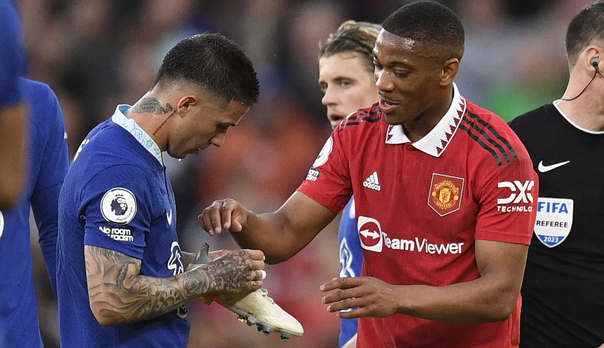 Pemain MU, Anthony Martial (kanan), mengambil sepatu miliknya dari tangan pemain Chelsea, Enzo Fernandez, dalam laga tunda pekan ke-32 Liga Inggris 2022/2023 yang berlangsung di Old Trafford, Jumat (26/5/2023). (AFP/Oli Scarff)