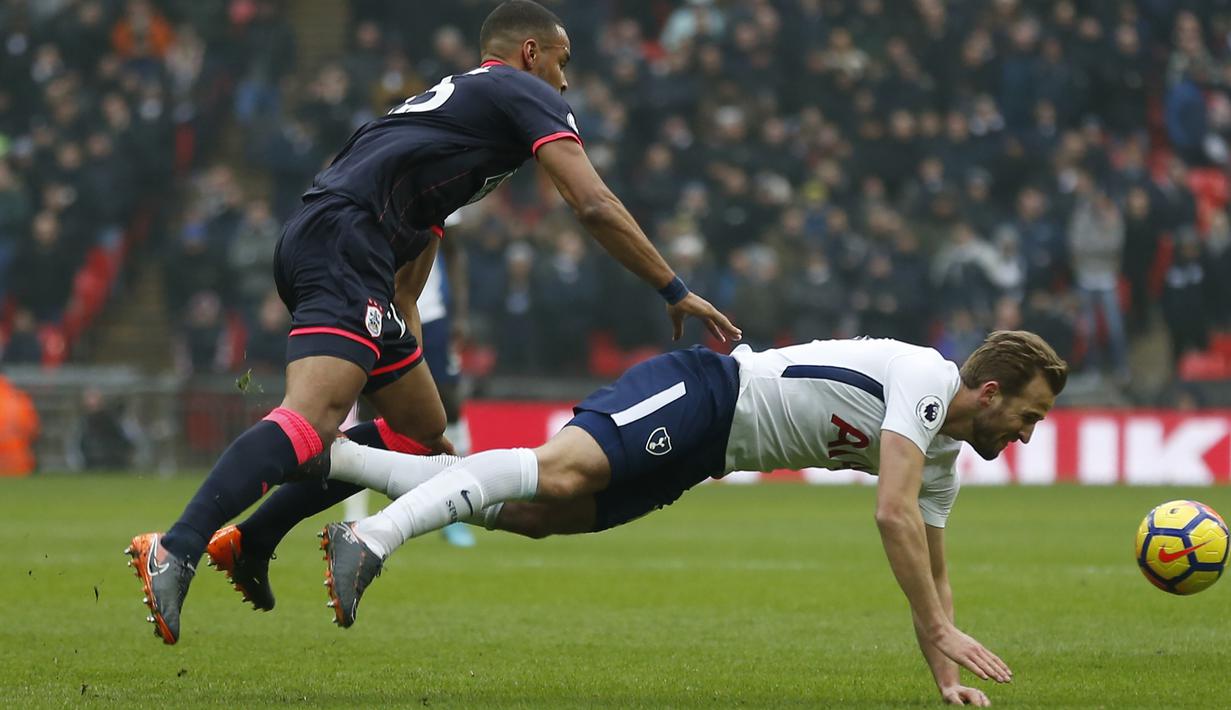 Aksi pemain Tottenham Hotspur, Harry Kane (kanan)  berebut bola dengan pemain Huddersfield Town, Mathias Jorgensen pada laga Premier League di Wembley Stadium, London, (3/3/2018). Tottenham menang 2-0. (AFP/Ian Kington)