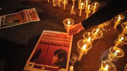 Poster terpidana mati Mary Jane diletakan di dekat lilin saat aksi gabungan komunitas buruh migran di depan Istana Merdeka, Jakarta, Minggu (26/4/2015). Aksi itu menyerukan penolakan atas hukuman mati di Indonesia. (Liputan6.com/Faial Fanani)