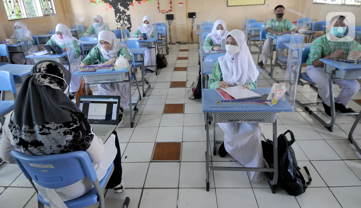 Guru melakukan kegiatan belajar tatap muka dengan penerapan protokol kesehatan COVID-19 di SMAN 2 Cibinong, Kabupaten Bogor, Jawa Barat, Rabu (17/3/2021). Sebanyak 170 sekolah di Kabupaten Bogor mulai menggelar uji coba pembelajaran secara tatap muka hingga 10 April 2021. (merdeka.com/Arie Basuki)