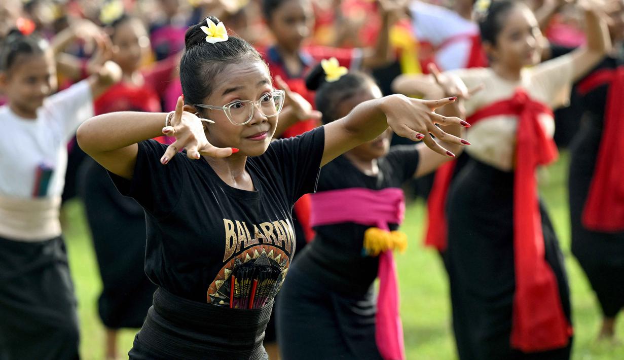 Tradisi ini juga memberi ruang bagi seniman muda untuk tampil sekaligus melestarikan seni budaya Bali. Tampak dalam foto, anak-anak menampilkan tarian tradisional untuk menyambut malam pergantian tahun di Bali, pada Rabu 31 Desember 2025. (SONNY TUMBELAKA/AFP)