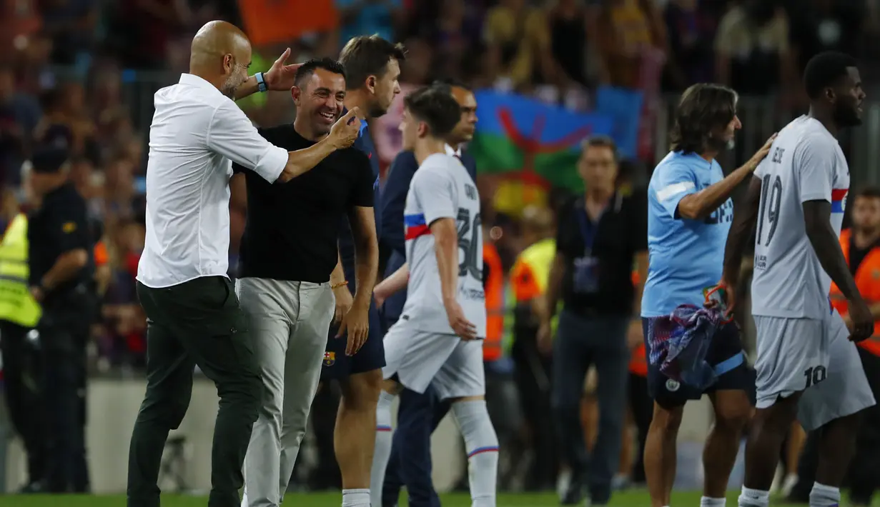 Manajer Manchester City, Pep Guardiola (kiri) menyapa pelatih Barcelona Xavi Hernandez pada akhir sebuah laga amal di Stadion Camp Nou, Kamis (25/8/2022) dinihari WIB. Pertandingan ini menjadi pertemuan perdana Pep Guardiola dan Xavi Hernandez yang pernah bekerja sama di Barcelona sebagai pelatih dan pemain selama rentang waktu 2008–2012. (AP Photo/Joan Monfort)