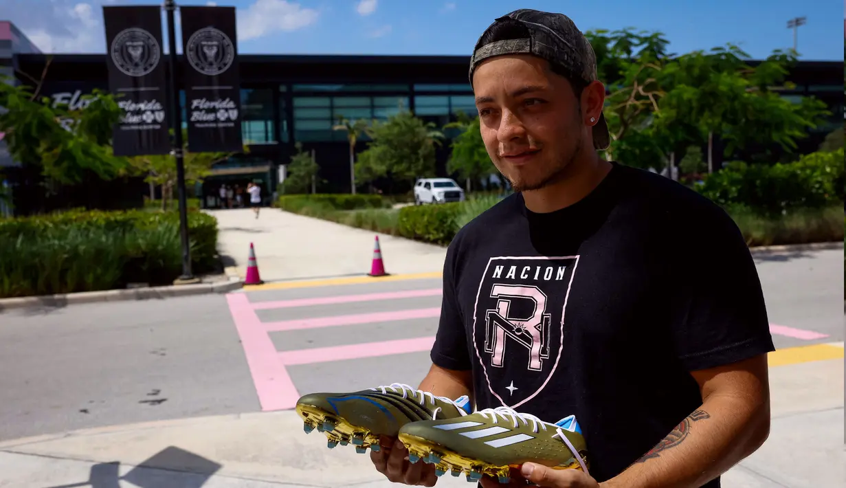 Seorang fans Inter Miami menunjukkan sepatu Adidas X Speedportal Cleats untuk dimintakan tanda tangan saat menunggu kedatangan Lionel Messi di DRV PNK Stadium, Fort Lauderdale, Florida, 11 Juli 2023 waktu setempat. Messi mendarat di Florida pada hari Selasa (11/07/2023) waktu setempat. Hal tersebut diketahui dari tayangan televisi ESPN. Inter Miami rencananya akan mengadakan acara presentasi bertajuk 'The Unveil' pada 16 Juli di stadion kandangnya. (AFP/Chandan Khanna)
