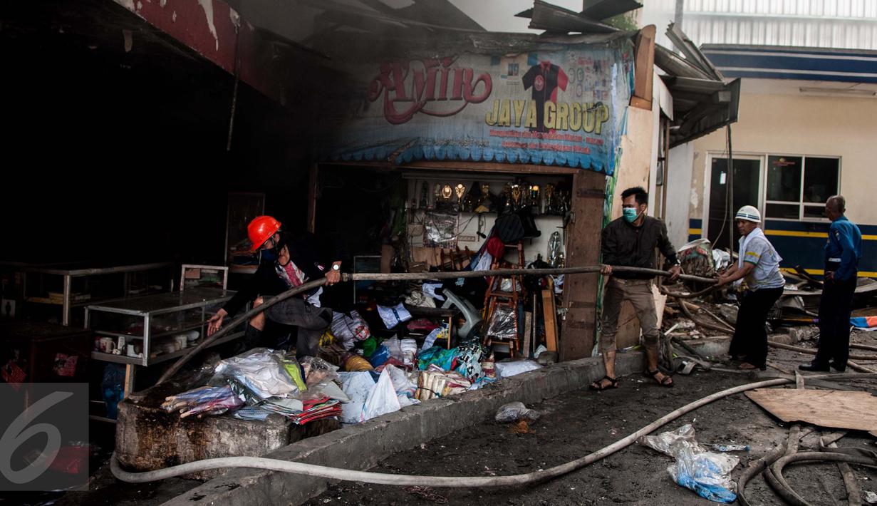 Petugas Damkar dibantu warga menyiapkan selang untuk memadamkan kebakaran yang melanda Pasar Senen, Jakarta, Kamis (19/1). Petugas Damkar mengerahkan sedikitnya 50 unit mobil pemadam untuk mengatasi kebakaran tersebut. (Liputan6.com/Gempur M Surya)