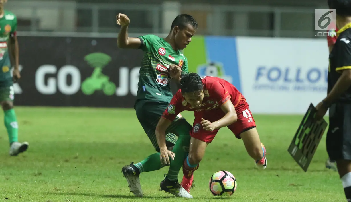 Gelandang PS TNI, Manahati Lestusen menahan pergerakan pemain Arema FC, Dendi Santoso saat laga lanjutan Liga 1 Indonesia di Stadion Pakansari, Bogor, Senin (3/7). Laga kedua tim berakhir imbang 0-0. (Liputan6.com/Helmi Fithriansyah)