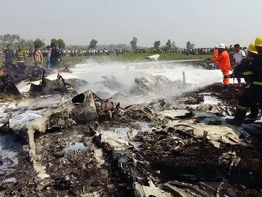 Petugas pemadam berupaya menjinakkan api dari puing-puing pesawat militer berukuran kecil yang jatuh sesaat setelah lepas landas di bandara Kota Naypidaw, Myanmar, Rabu (10/2). Sedikitnya empat orang tewas dalam kecelakaan ini. (AFP/PHOTO/AUNG Htet)