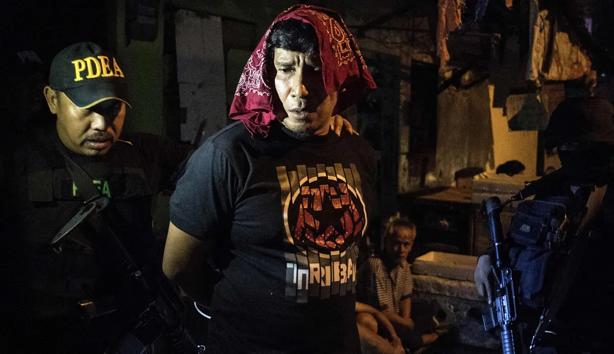 Pengedar narkoba ditangkap saat penggerebekan di Desa Maharlika, Taguig, selatan Manila (28/2). Perang terhadap narkoba di Filipina atas pemerintah Presiden Rodrigo Duterte telah menyebabkan hampir 4.000 tersangka narkoba tewas. (AFP Photo/Noel Celis)