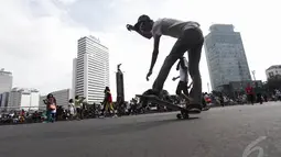 Aksi seorang remaja bermain skateboard di kawasan Bundaran HI Jakarta, Minggu (14/12/2015). (Liputan6.com/Faizal Fanani)