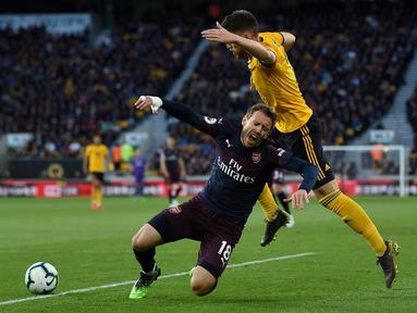 Bek Arsenal, Nacho Monreal dilanggar pemain Wolves, Matt Doherty pada laga lanjutan Premier League yang berlangsung di Stadion Molineux, Wolverhampton, Kamis (25/4). Arsenal kalah 1-3 kontra Wolves. (AFP/Paul Ellis)