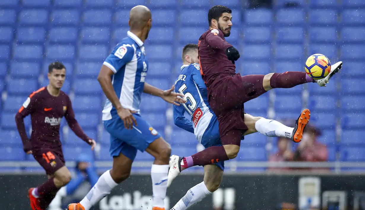 Aksi pemain Barcelona, Luis Suarez (kanan) menjangkau bola dari kepuungan pemain Espanyol pada lanjutan La Liga santander di RCDE stadium, Cornella Llobregat, Spanyol, (4/2/2018). Espanyol dan Barcelona bermain imbang 1-1.  (AP/Manu Fernandez)