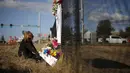 Seorang wanita menaruh bunga saat melakukan aksi simpatik mengenang korban penembakan di Kampus Umpqua Community College di Roseburg, Sabtu (3/10/2015). Setidaknya 15 orang tewas dalam peristiwa tersebut. (REUTERS / Lucy Nicholson)