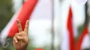 Pendukung Cagub DKI Basuki T Purnama memberikan salam dua jari saat sidang kasus penistaan agama, Jakarta, Selasa (10/1). Dengan mengenakan atribut kotak-kotak, massa membawa bendera Indonesia serta melakukan orasi damai. (Liputan6.com/Immanuel Antonius)