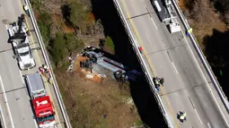 Petugas penyelamat mengevakuasi bangkai bus carteran yang kecelakaan di Loxley, Alabama (13/3). Dilaporkan sopir dari bus ini meninggal, dan puluhan penumpang mengalami luka berat. (AP Photo / Dan Anderson)