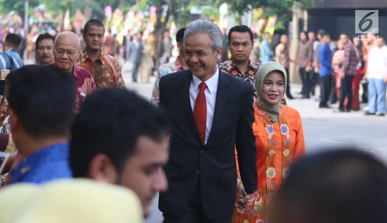 Gubernur Jawa Tengah Ganjar Pranowo beserta istri menuju Gedung Graha Saba Buana, Solo, Rabu (8/11). Sejumlah tokoh nasional dan pejabat menghadiri Ijab Kabul pernikahan putri Presiden Jokowi, Kahiyang Ayu dengan Bobby Nasution (Liputan6.com/Angga Yuniar)