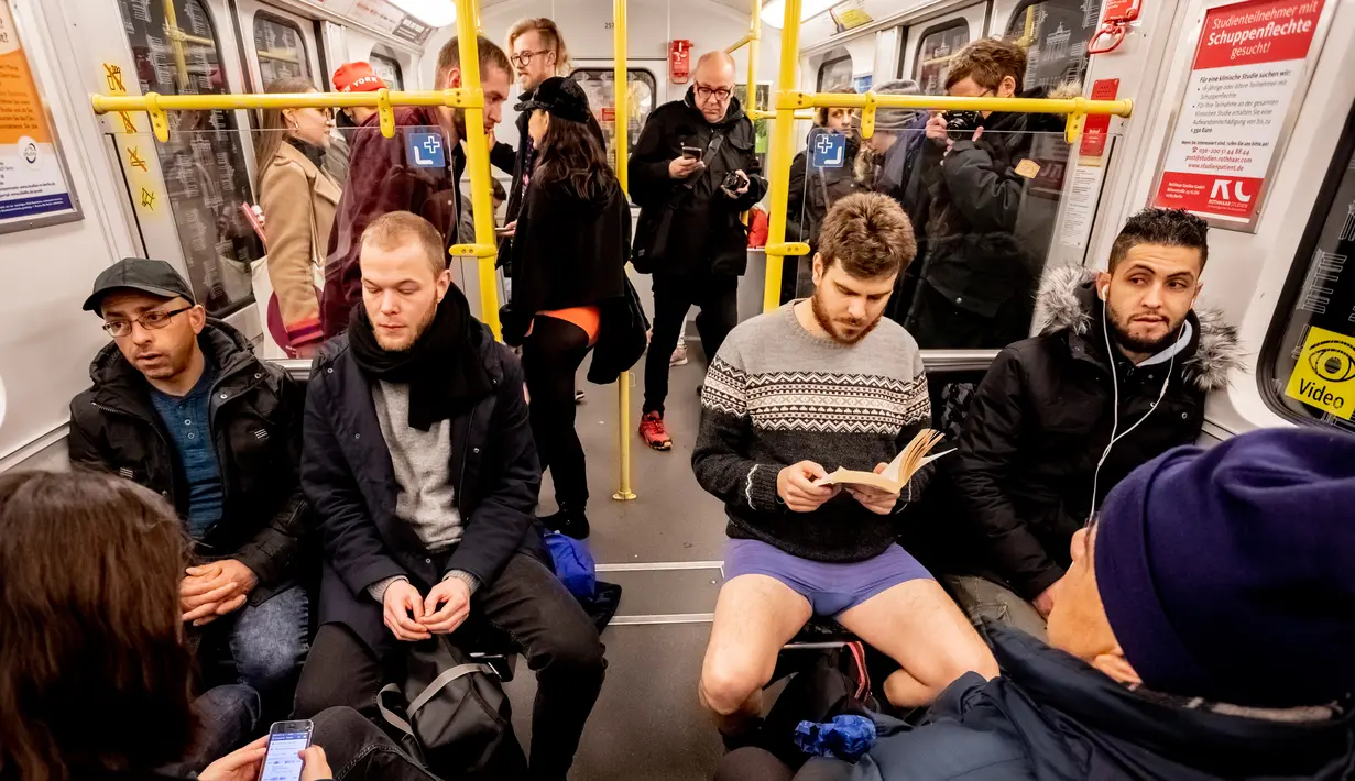 Seorang pria tanpa mengenakan celana membaca buku selama No Pants Subway Ride di sebuah kereta bawah tanah di Berlin, Jerman (13/1). Acara ini dimulai pada tahun 2002 dengan peserta hanya tujuh orang. (AFP Photo/Christoph Soeder)