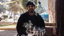 Khaled al-Hamo duduk di depan tenda mereka di kamp darurat pengungsi korban gempa Turki dan Suriah di kota Antakya pada 19 Februari 2023. Jutaan orang di seluruh wilayah telah kehilangan tempat tinggal akibat gempa. Banyak yang terpaksa tinggal di tenda-tenda dengan sanitasi atau akses listrik dan perawatan kesehatan serba terbatas. (Sameer Al-DOUMY / AFP)