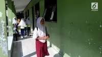 Seorang siswi SMP tak mampu beli seragam putih-biru. Dia terpaksa ke sekolah pakai seragam SD dan sandal jepit. | Sumber Foto: Liputan6.com