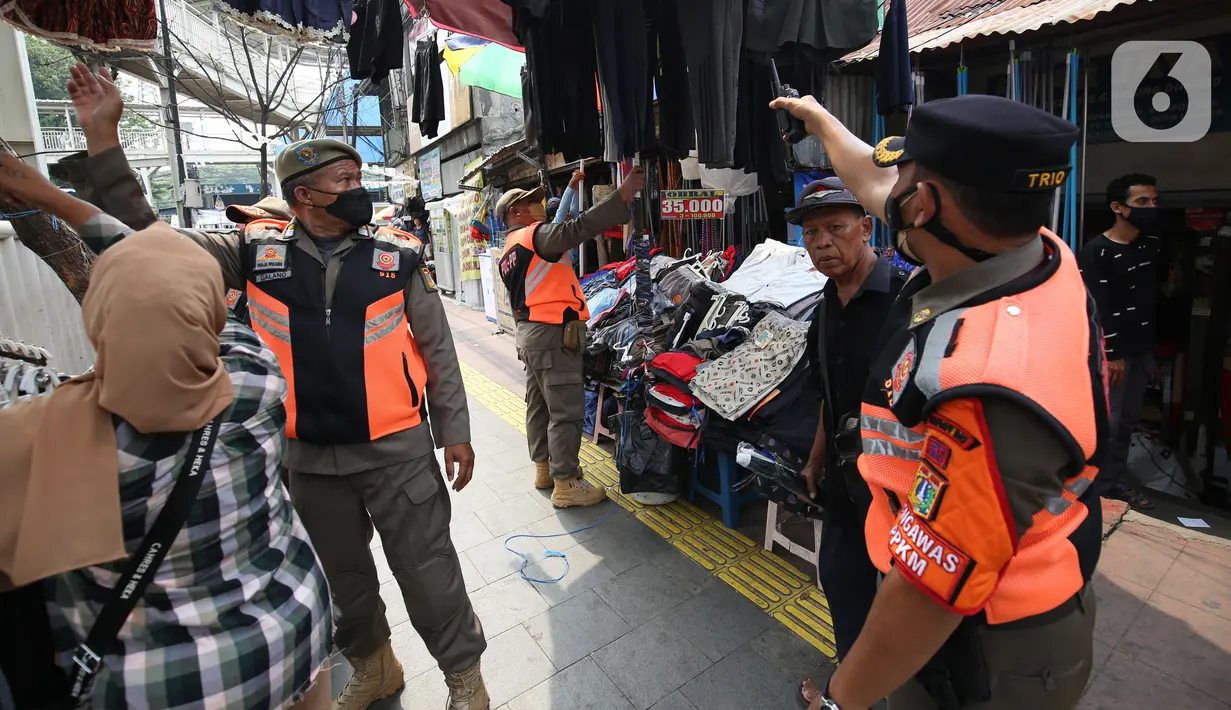 Petugas Satpol PP melakukan penertiban kepada pedagang kaki lima (PKL) yang bandel berjualan di trotoar Pasar Tanah Abang, Jakarta, Senin (4/10/2021). Penertiban dilakukan untuk memberikan kenyamanan dan keamanan bagi para pengguna jalan yang melintas di trotoar tersebut. (Liputan6.com/Angga Yuniar)