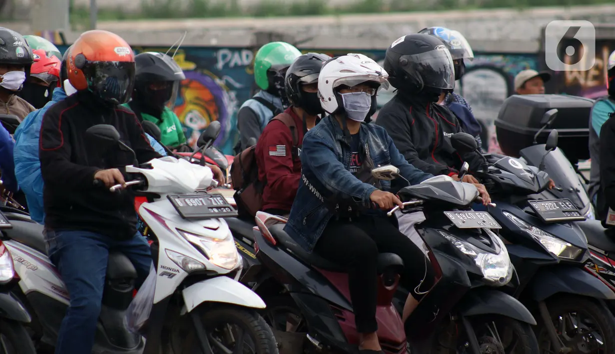 Pengendara motor di pemberhentian lampu Merah, Kota Depok, Jawa Barat, Minggu (12/4/2020). Menteri Kesehatan menyetujui menerapkan Pembatasan Sosial Berskala Besar (PSBB) di wilayah Kota Depok yang akan dimulai, Rabu (15/4) dalam pencegahan meluasnya COVID-19. (Liputan6.com/Helmi Fithriansyah)