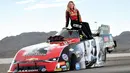 Pembalap Courtney Force berpose di atas mobil balap Chevrolet Camaro SS yang didesain dengan cover album terbaru Taylor Swift "Reputation" disiapkan di Las Vegas, Nevada (10/11). (AFP Photo/Getty Images/AFP)