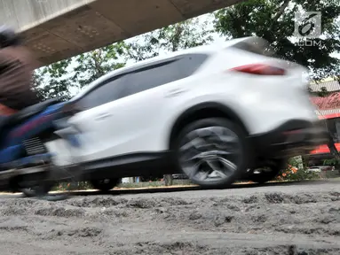 Kendaraan melintas di jalan rusak yang berada di kawasan Kelapa Gading, Jakarta, Rabu (5/9). Permasalahan jalan rusak dan berlubang di kawasan tersebut hingga kini belum juga teratasi. (Merdeka.com/Iqbal S. Nugroho)