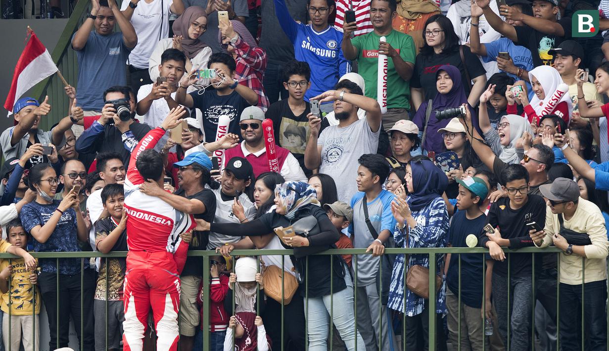 Pebalap sepeda BMX Indonesia, I Gusti Bagus Saputra, menghampiri suporter saat berlaga pada Asian Games di BMX Center, Jakarta, Sabtu (25/8/2018). Bagus Saputra meraih medali perak dengan catatan waktu 34,314 detik. (Bola.com/Peksi Cahyo)