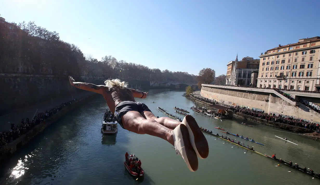 Seorang pria Italia bernama, Maurizio Palmulli melompat ke Sungai Tiber dari jembatan Cavour, Roma, Italia (1/1). Tradisi tahun baru di Italia ini sebelumnya pernah vakum, hingga akhirnya di rayakan kembali. (Reuters/Alessandro Bianchi)