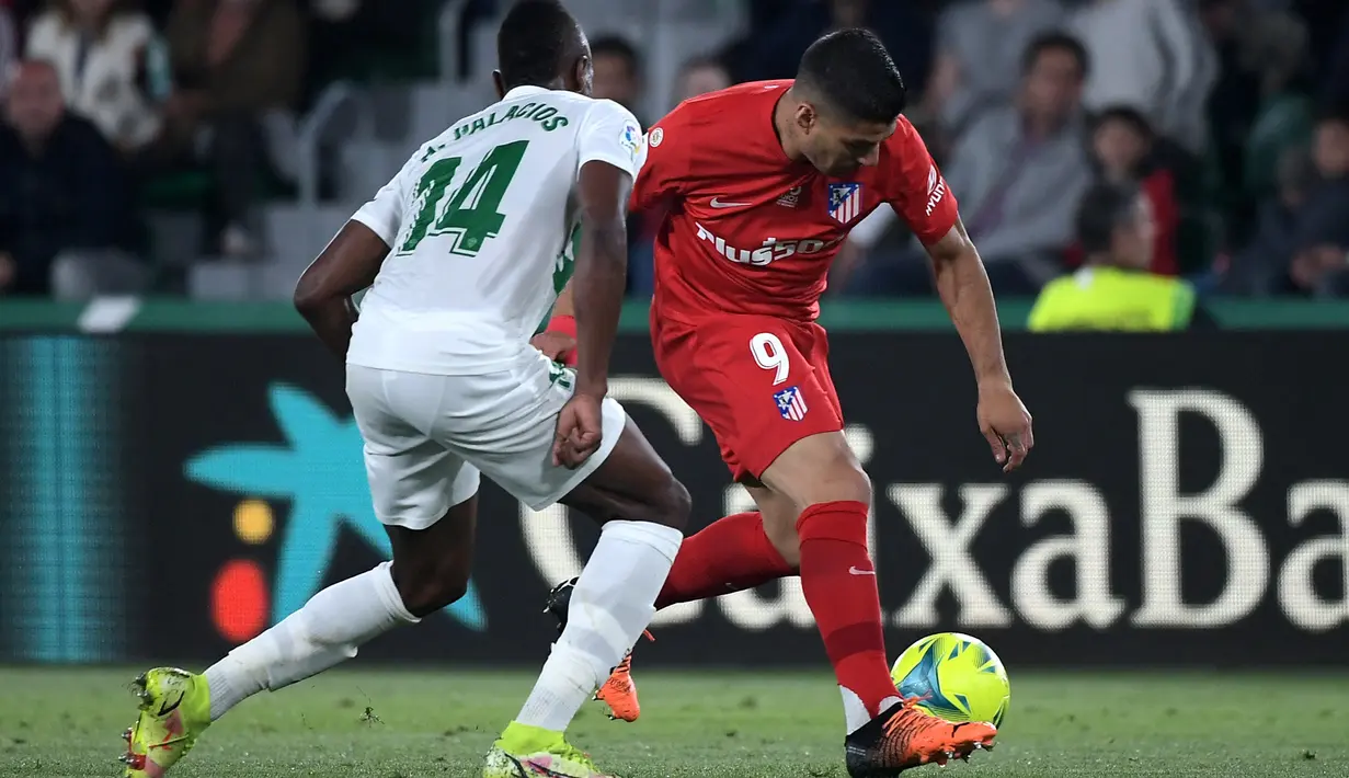 <p>Bek Elche CF Helibelton Palacios (kiri) berebut bola dengan pemain depan Atletico Madrid Luis Suarez pada jordana ke-36 La Liga Spanyol 2021/2022 di Estadio Martinez Valero, Kamis (12/5/2022) dini hari WIB. Atletico Madrid sukses menaklukkan tuan rumah Elche dengan skor meyakinkan 2-0. (JOSE JORDAN / AFP)</p>