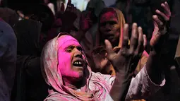 Seorang janda menari saat menikmati perayaan Holi di sebuah kuil di Vrindavan, Uttar Pradesh, India (21/3). Kehadiran kaum janda dianggap tidak menguntungkan pada perayaan keagamaan (REUTERS/Anindito Mukherjee)