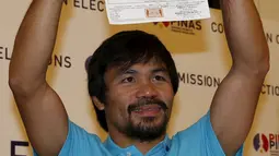 Manny Pacquiao mengangkat Sertifikat Pencalonan Senator  dirinya di Mei 2016 pemilihan nasional, di Komisi Pemilihan Umum, Manila, Filipina (16/10/2015). Pacquiao ditemani istrinya Jinkee dan anaknya Michael. (REUTERS/Erik De Castro)