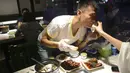 Pengunjung menyeka mulut rekannya saat menikmati hidangan kepala kelinci di sebuah restoran di Chengdu, ibu kota Provinsi Sichuan di barat daya China, 8 September 2016. Di sini, otak kelinci menjadi menu favorit warga lokal maupun asing. (WANG ZHAO/AFP)