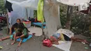 Warga mengungsi di tenda yang didirikannya di jalan Desa Sumber Urip Pebayuran, Senin (22/2/2021). Sudah tiga hari warga bertahan di tenda pengungsian dikarenakan banjir luapan sungai Citarum yang merendam permukiman warga kampung Babakan Banten Pebayuran. (Liputan6.com/Herman Zakharia)