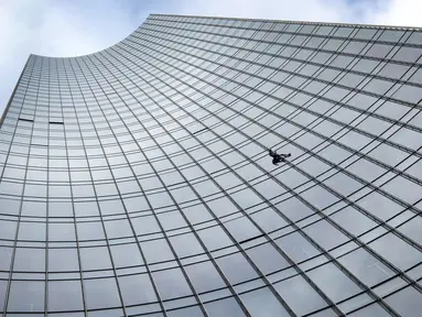 Pendaki kota Prancis, Alain Robert saat berusaha memanjat gedung XYZ di Frankfurt am Main, Sabtu (28/9/2019). Alain yang dikenal sebagai "The French Spiderman" kembali memanjat gedung tinggi di kota Jerman tersebut. (AFP Photo/Daniel Roland)