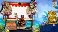 Dalang cilik Adimas Alby Ersani Widyaputra yang juga youtuber konten wayang memainkan wayang kulit dihadapan Menteri Parekraf Sanidaga Uno di desa wisata Rejowinangun, Yogyakarta, Jumat (08/10/2021). Alby merupakan keturunan ke 9 dari kakek buyutnya bernama Mbah Gondo. (Liputan6.com/HO/Parekraf)