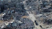 Foto udara memperlihatkan orang-orang berjalan melewati reruntuhan rumah di Rafah, Jalur Gaza Selatan pada 20 Januari 2025. (Foto oleh AFP)