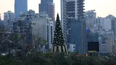 Sebuah pohon Natal dengan daftar nama korban yang tewas dalam insiden ledakan di Pelabuhan Beirut terlihat di dekat silo gandum yang rusak di Beirut, Lebanon (22/12/2020). Dua ledakan besar mengguncang Pelabuhan Beirut pada 4 Agustus lalu. (Xinhua/Bilal Jawich)