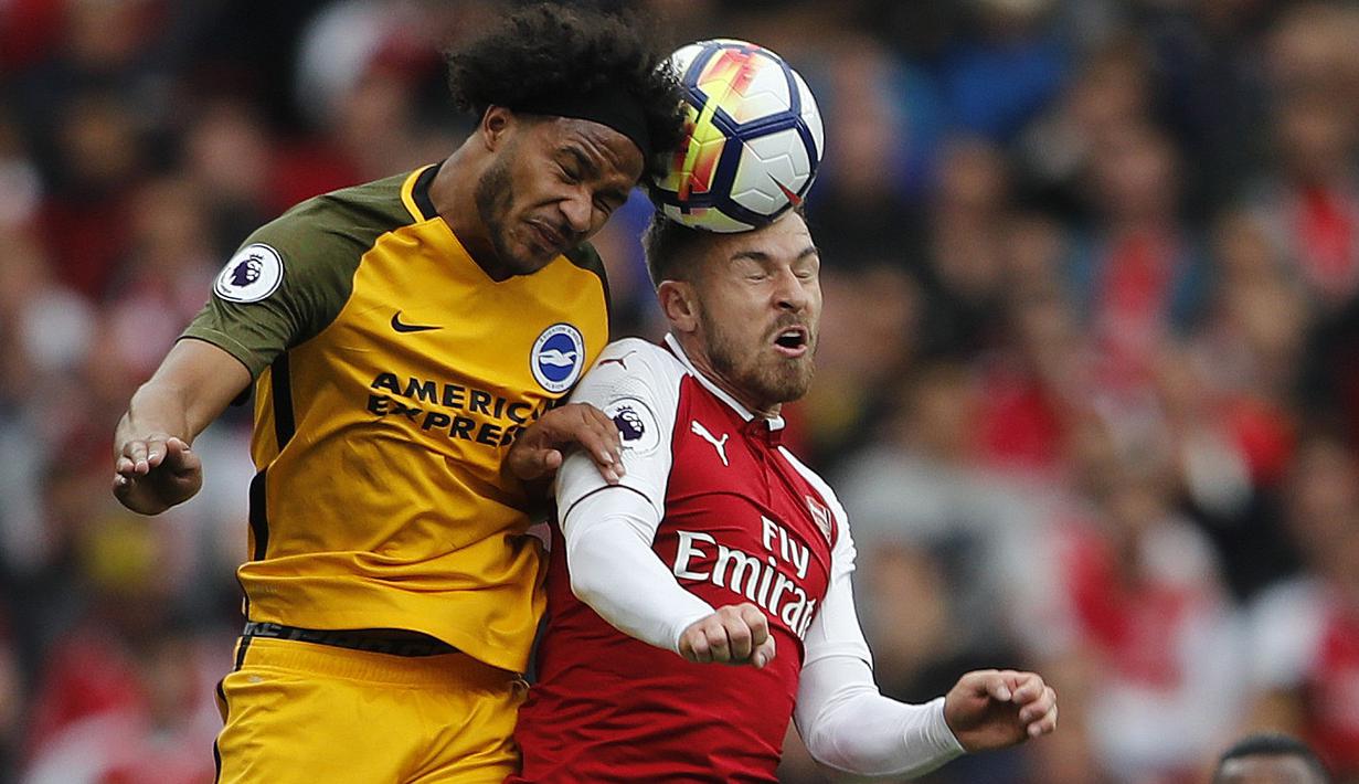 Duel pemain Brighton, Gaetan Bong (kiri) dengan pemain Arsenal, Aaron Ramsey pada lanjutan Premier League di Emirates Stadium, London, (1/10/2017). Arsenal menang 2-0. (AP/Frank Augstein)