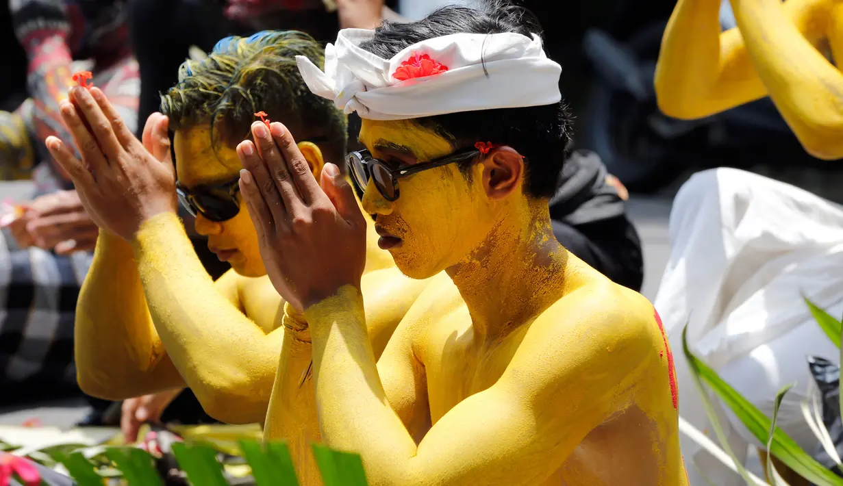 Para pemuda berdoa selama  ritual Hindu yang disebut "Grebeg" di Desa Tegallalang, Bali, Rabu (30/1). Dalam ritual dua tahunan ini, para pemuda berkeliling kampung dengan riasan tubuh warna-warni untuk menangkal Roh jahat. (AP/Firdia Lisnawati)