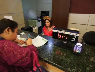 Teller berpakaian daerah melayani nasabah yang melakukan transaksi di Kantor Cabang Khusus (KCK) BRI, Jakarta, Jumat (21/4). Memperingati Hari Kartini, seluruh pegawai BRI mengenakan pakaian daerah dalam melayani nasabahnya. (Liputan6.com/Faizal Fanani)