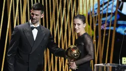 Aitana Bonmati didaulat naik panggung dan menerima Ballon d'Or Feminin 2023 dari legenda tenis Novak Djokovic. (AP Photo/Michel Euler)