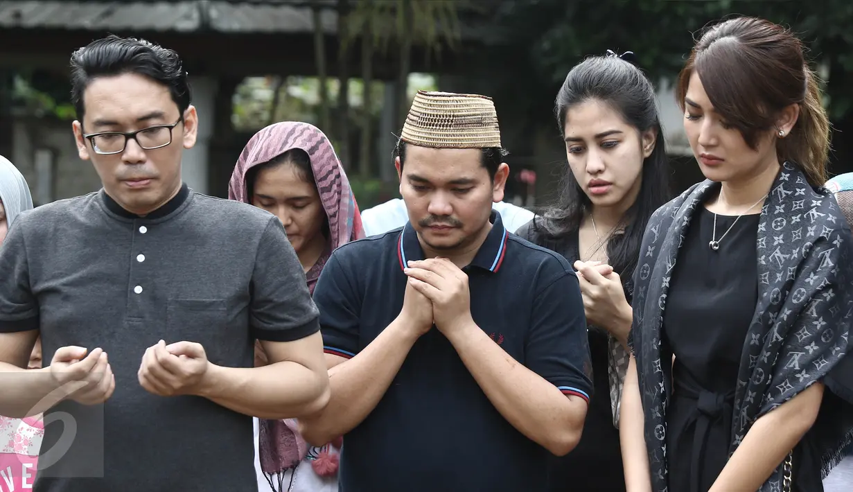 Presenter Indra Bekti didampingi kerabat berdoa saat proses pemakaman anak ketiganya di TPU Kamboja, Radio Dalam,  Jakarta, Rabu (1/2). Istri Bekti, Aldilla Jelita, melahirkan saat usia kandungannya baru mencapai lima bulan. (Liputan6.com/Herman Zakharia)