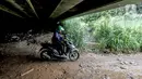 Pengendara sepeda motor melintas di kolong Tol Jagorawi, Cimanggis, Depok, Jawa Barat, Minggu (8/11/2020). Buruknya jalan dan minimnya penerangan membuat akses tersebut rawan aksi kejahatan. (Liputan6.com/Faizal Fanani)