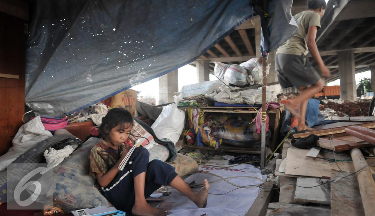 Seorang anak terlihat belajar meski dengan kondisi tempat tinggal yang memperihatinkan, Jakarta, Jumat (16/9). Sebelumnya, 50 bangunan liar di bawah kolong Tol Sedyatmo, Penjaringan kembali ditertibkan Pemkot Jakut. (Liputan6.com/Yoppy Renato)