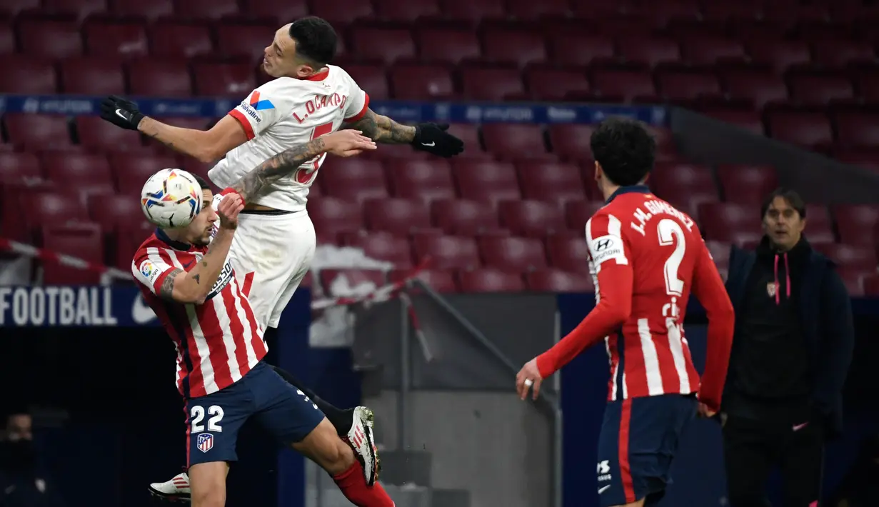 Bek Atletico Madrid, Mario Hermoso (kiri) bersaing dengan gelandang Sevilla, Lucas Encamps dalam lanjutan Liga Spanyol 2020/2021  di Stadion Wanda Metropolitano, Madrid, Spanyol, Rabu (13/1/2021) dini hari WIB. Atletico Madrid membungkam Sevilla dengan skor 2-0. (PIERRE-PHILIPPE MARCOU / AFP)