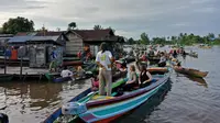 Wisatawan asing sedang menikmati berinteraksi dengan pedagang di Pasar Terapung Lok Baintan, Banjarmasin (Liputan6.com/Pool/Kadek Arini)
