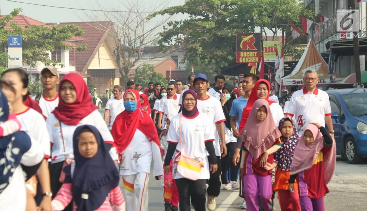 Peserta mengikuti jalan sehat di Mempawah, Kalimantan Barat, Minggu (18/8/2019). Memperingati HUT ke-74 RI tiga BUMN yakni PT Asuransi Kredit Indonesia atau Askrindo (Persero), Perum Perindo dan PT Perkebunan Nusantara XIII menggelar jalan sehat. (Liputan6.com/HO/Iqbal)