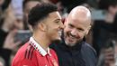 Pemain Manchester United, Jadon Sancho, tersenyum saat akan dimasukkan Erik ten Hag melawan Nottingham Forest pada leg kedua babak semifinal Carabao Cup, Stadion Old Trafford, Jumat (2/2/2023). Setelah cukup lama hilang, Sancho muncul di skuad United pada duel lawan Nottingham. Pada menit ke-63, Sancho dimainkan untuk menggantikan Antony. (AFP/Paul Ellis)